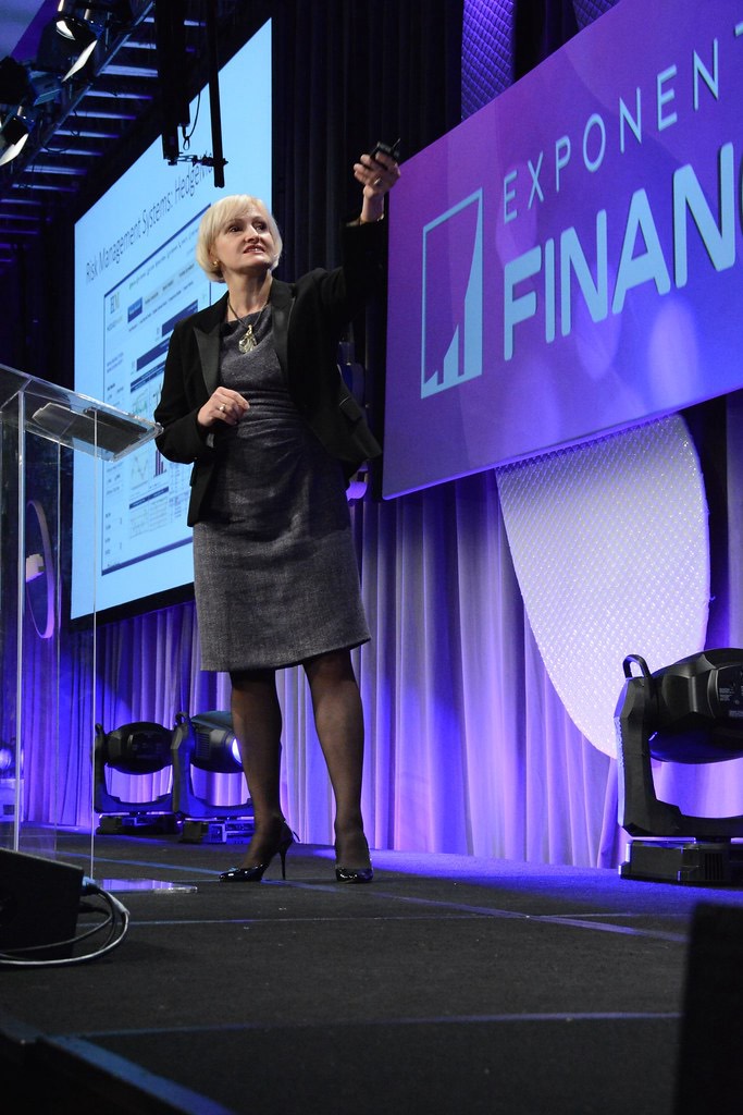 Victoria Vysotina presenting on stage at a finance conference